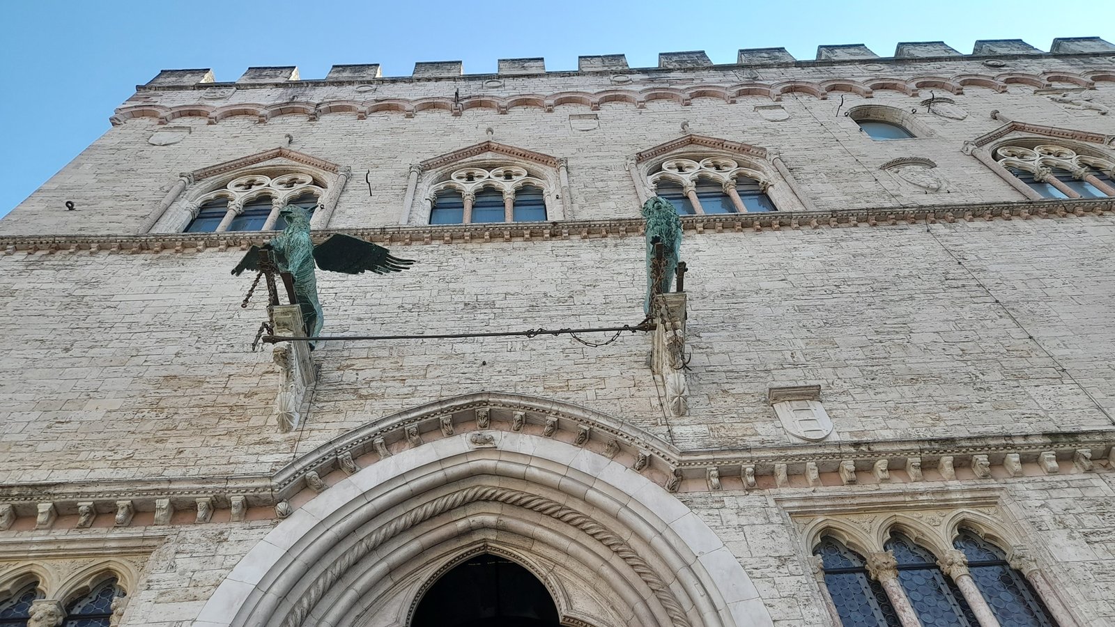 The Gothic facade of Palazzo dei Priori in Perugia, with its bronze griffin and lion.