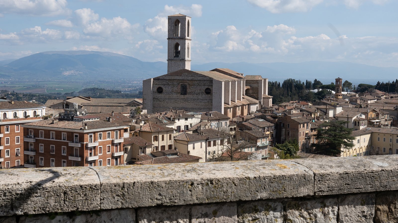 The rooftops of Perugia and a bell tower, with the Umbrian hills beyond.