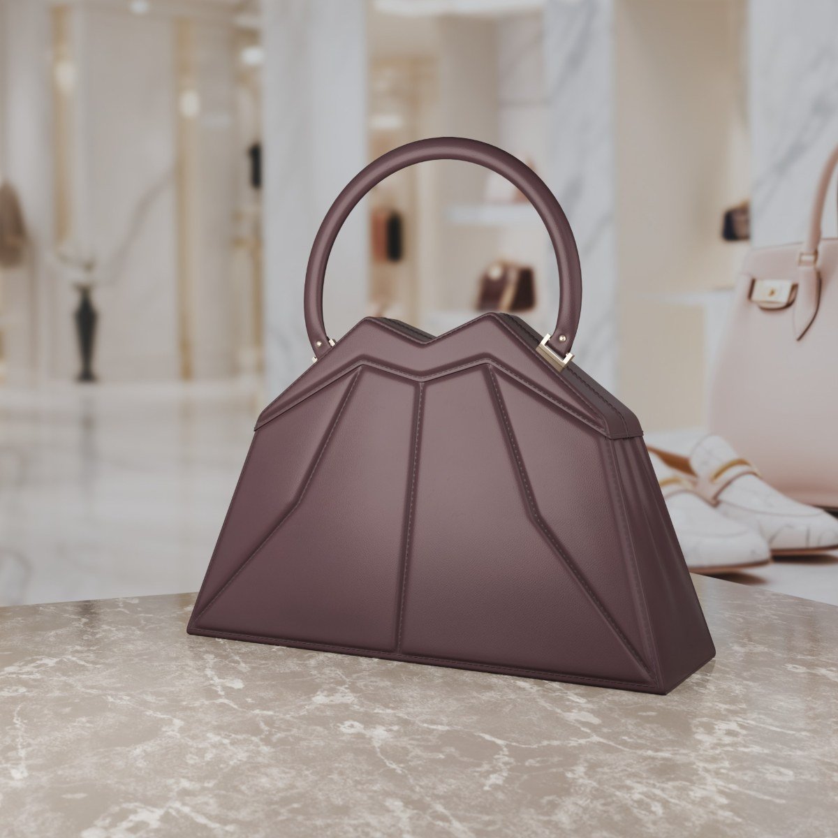 A burgundy leather bag with faceted, folded panels and a round top handle.