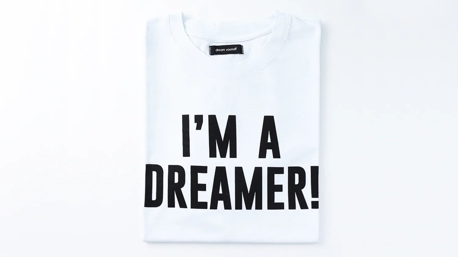 Folded white T-shirt printed with the words “I’M A DREAMER!”